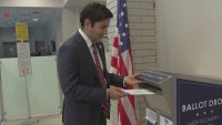 Neil Makhija, chair of the Montgomery County Board of Elections, displays how to return a mail-in ballot during an event to detail new efforts to improve election security.